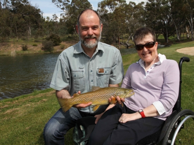 A couple holding a big brown trout