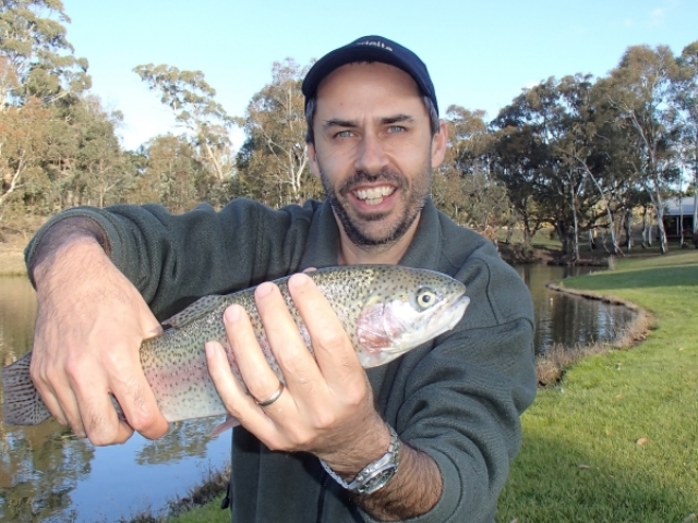 A man holding a rainbow after catching it by moving the flies very slowly