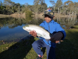 A young man with his shiny silver rainbow trout
