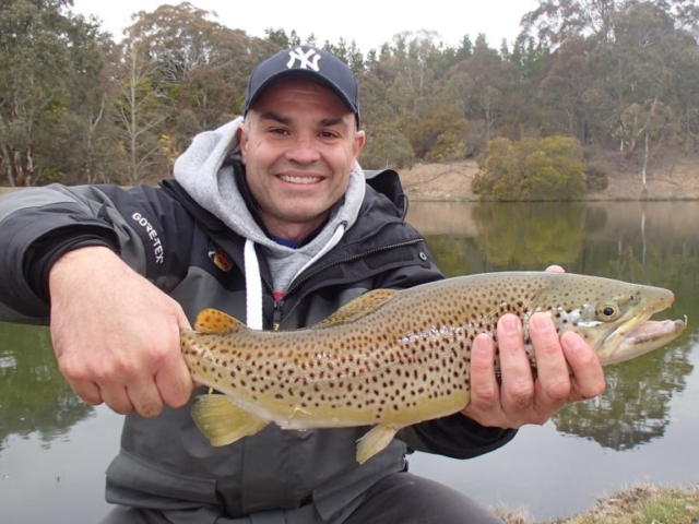 A man about to release a beautiful borwn trout