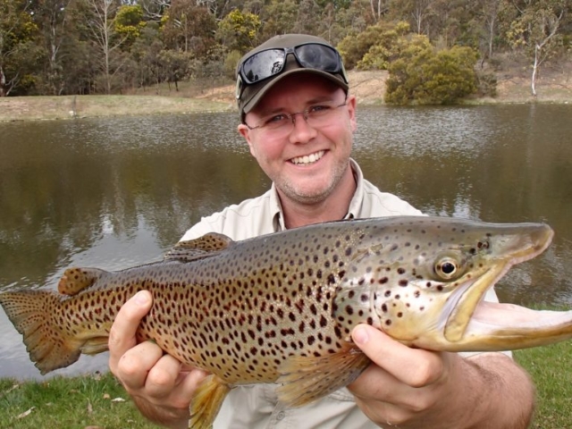 A happy man with a huge brown trout