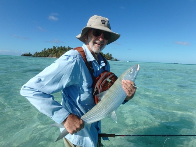 A man smiling holding his big Bonefish on Aitutaki