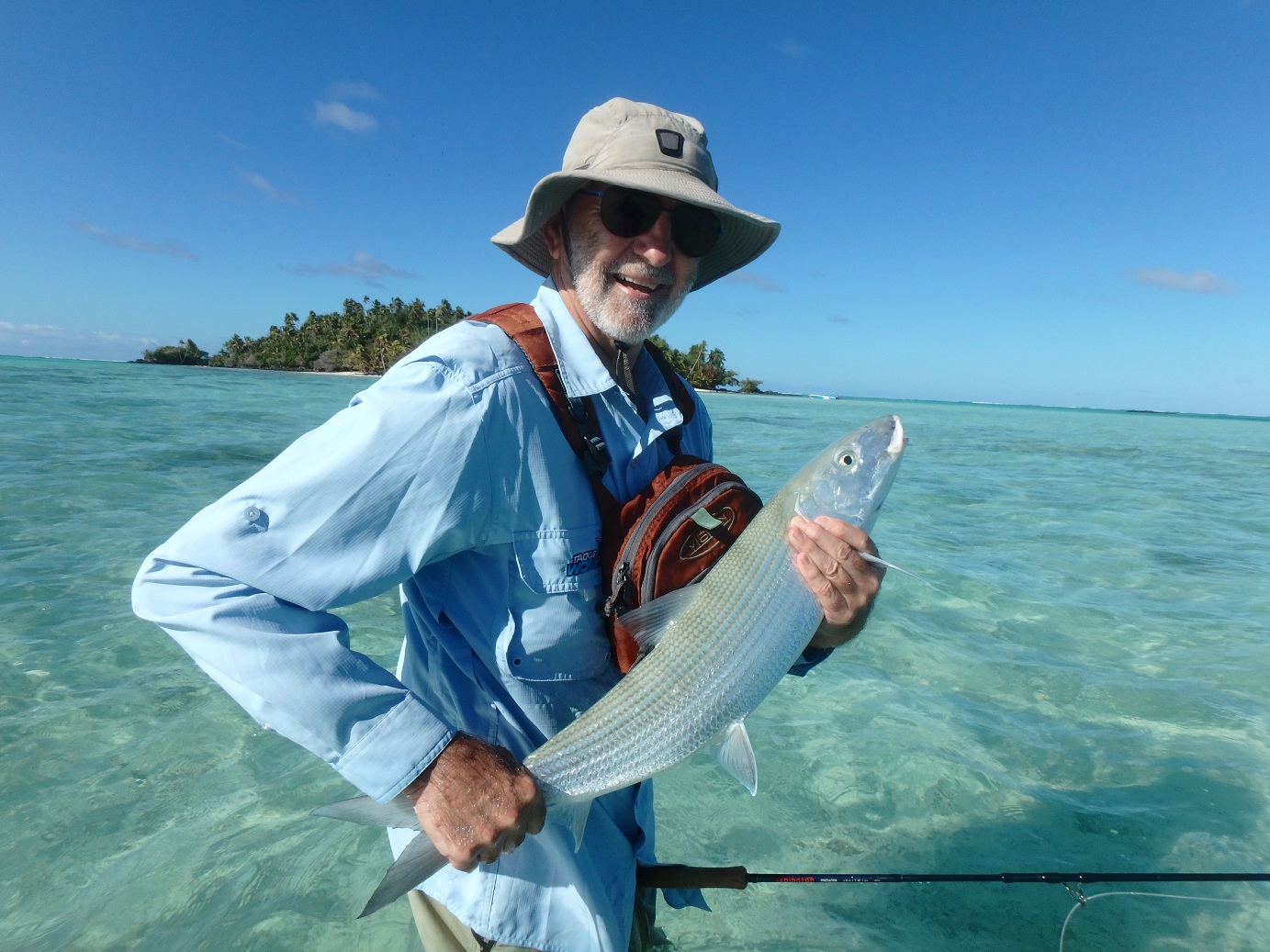 A man smiling holding his big Bonefish on Aitutaki