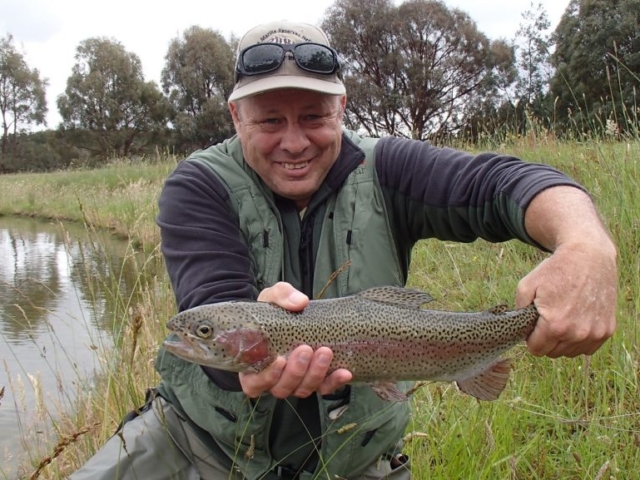 A man holding a rainbow trout in mid September