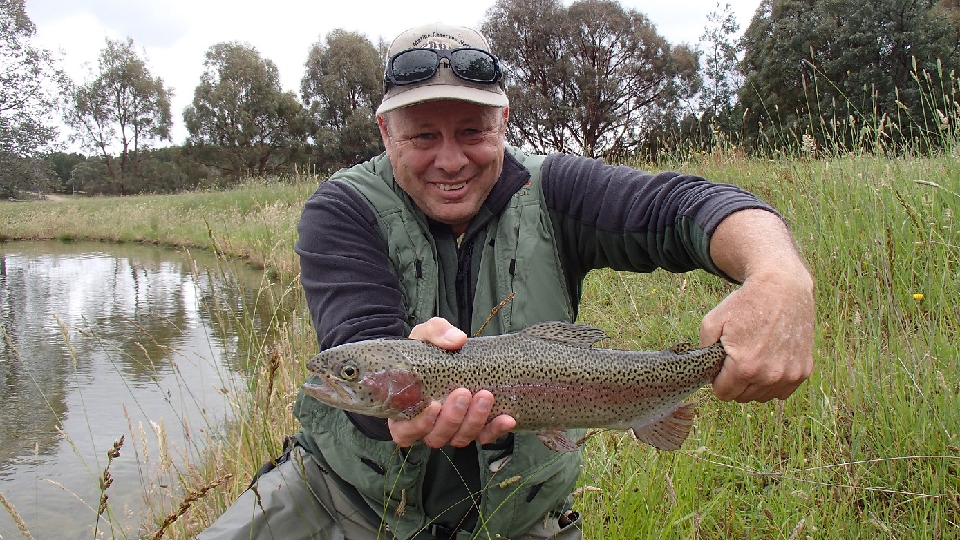 A man holding a rainbow trout in mid September