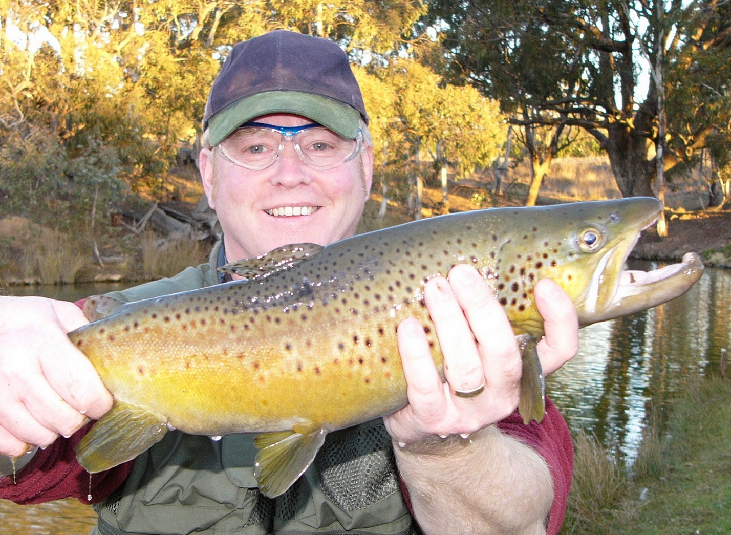 A man showing off his brown trout after learning new techniques
